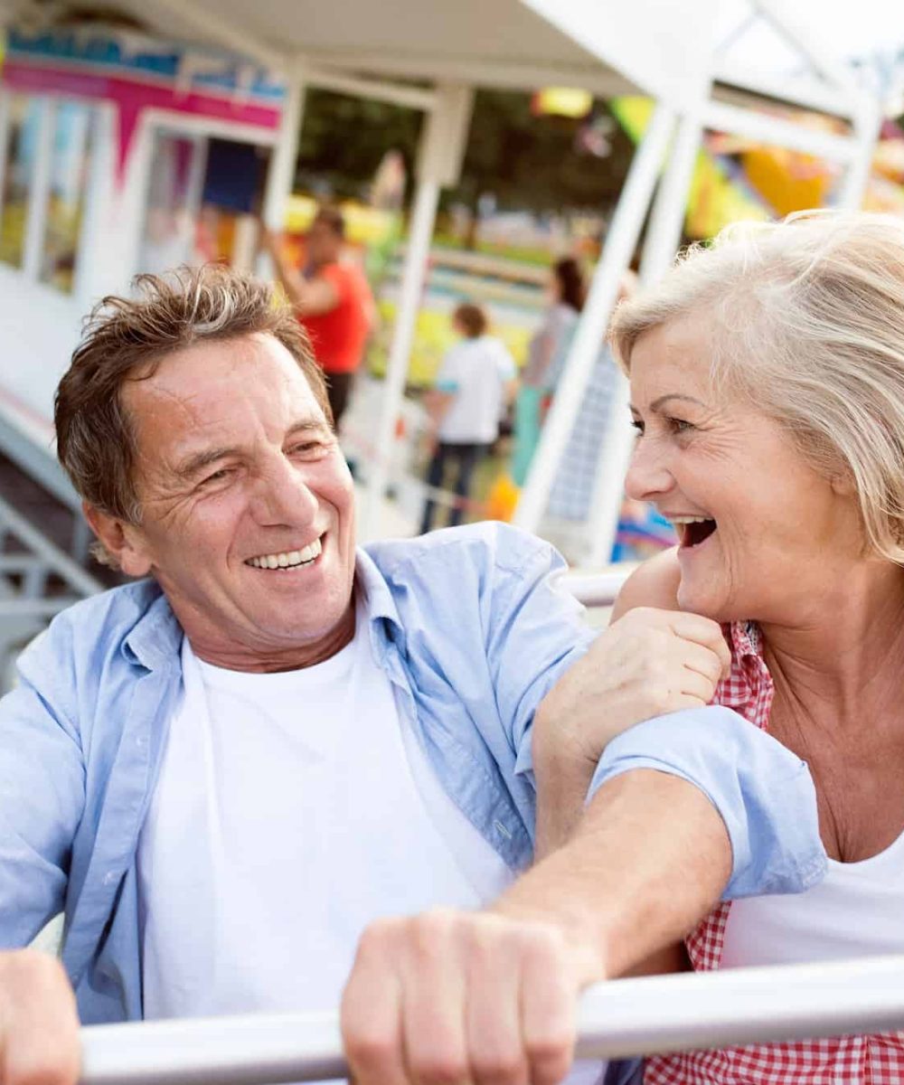 Senior couple on a ride in amusement park
