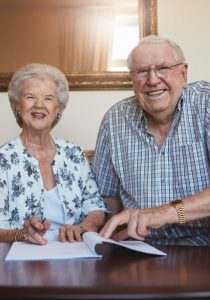 Smiling retired couple looking over documents