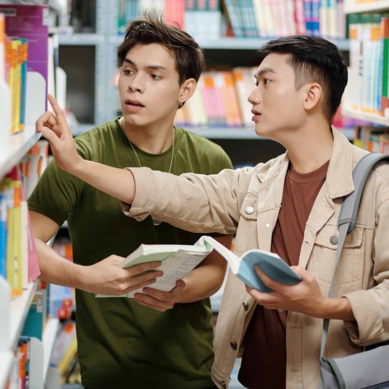 Teenager Helping Classmate to Find Book